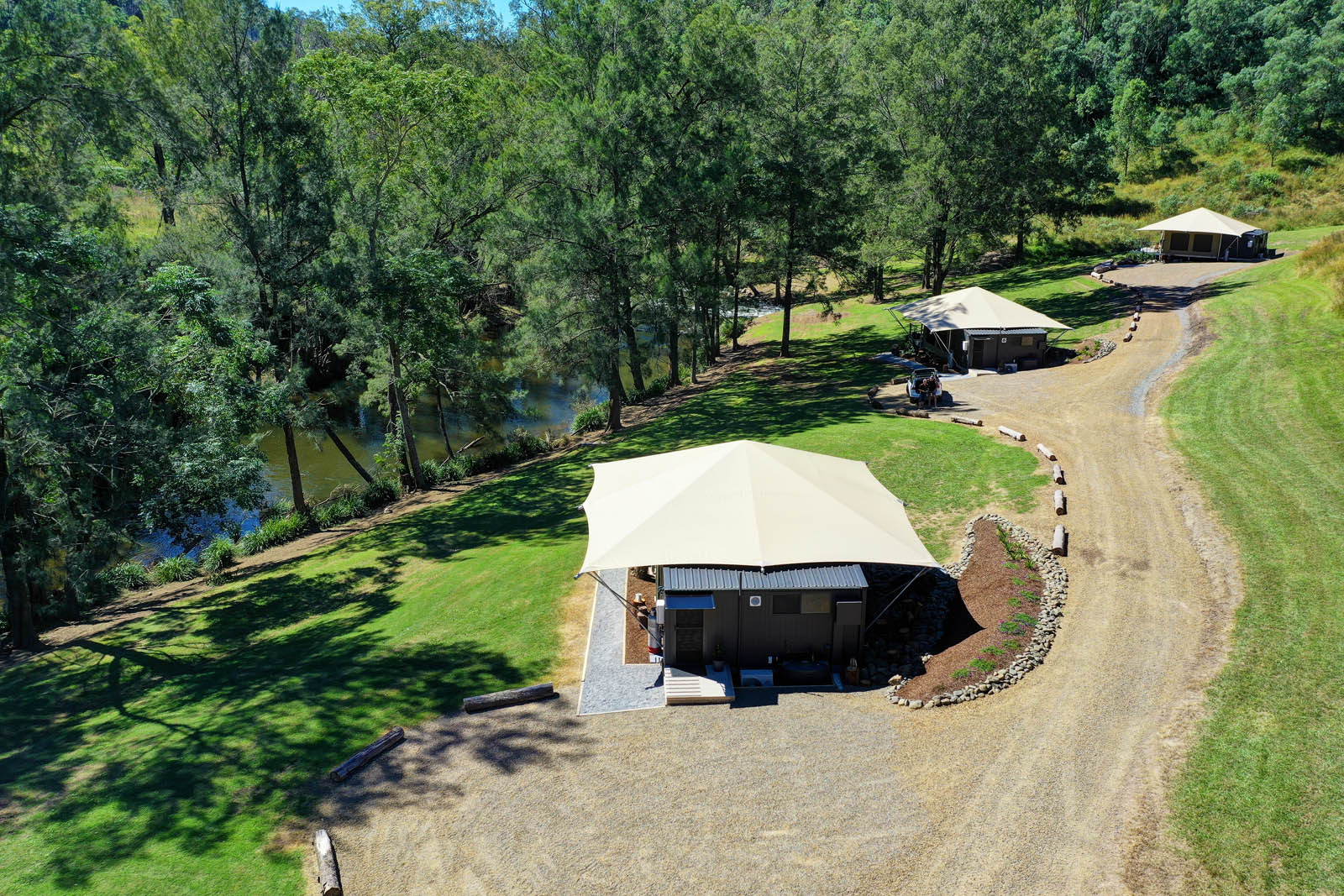 Luxury safari tent beside the river with a winding path through the lawn